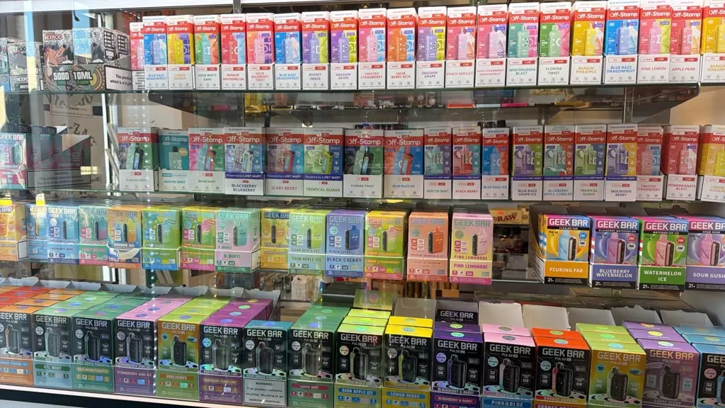 Rows of disposable vapes in the display case