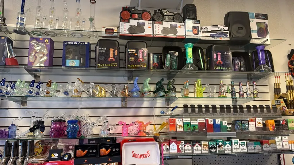 Glass pieces, e-rigs, and cigarette brands on the wall